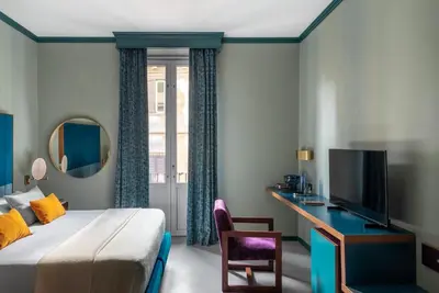 a bedroom with a large bed and two windows at Hotel Milani in Rome