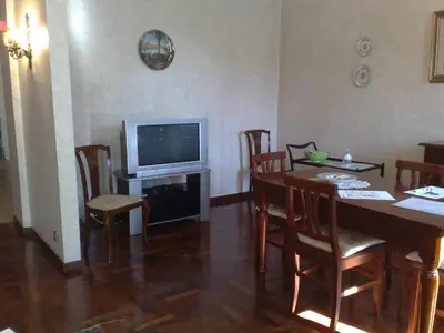 a dining room with a table and a television at Amici di Roma in Rome