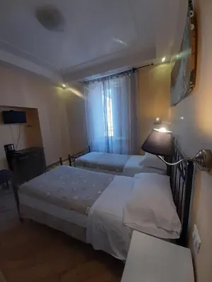 a bedroom with two beds and a lamp at B&B Rome With Love in Rome