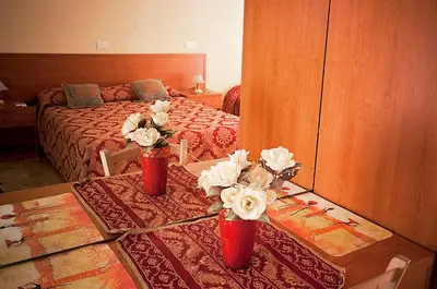 a bedroom with a bed and two vases with flowers on a table at Parioli House in Rome