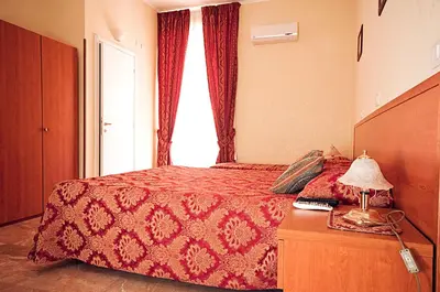 a bedroom with a bed with a red bedspread and a window at Parioli House in Rome