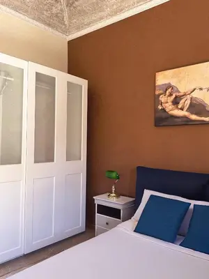 a bedroom with a white bed with blue pillows at House Montebello in Rome