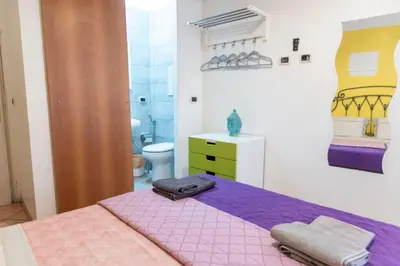 a bedroom with a purple bed and a bathroom at fruitroom rome in Rome