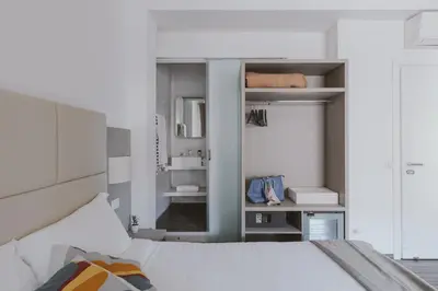 a bedroom with a white bed and a mirror at Residenza Il Duca in Rome