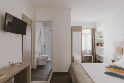 a white bedroom with a bed and a bathroom at Residenza Il Duca in Rome