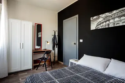 a bedroom with a black wall and a bed and a desk at Radio Hotel in Rome