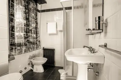 a white bathroom with a sink and a toilet at Radio Hotel in Rome