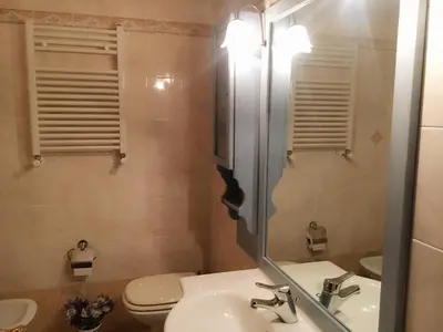 a bathroom with a sink and a toilet and a mirror at Hostel Cosmos in Rome