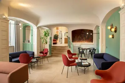a waiting room with chairs and tables in a building at Hotel Colosseum in Rome