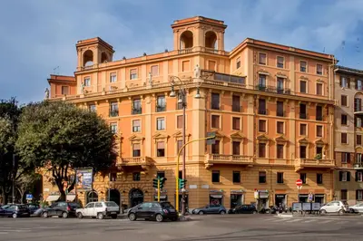 a large orange building with cars parked in front of it at Best Western Hotel Astrid in Rome