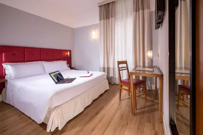 a hotel room with a bed with a laptop on it at Best Western Hotel Astrid in Rome