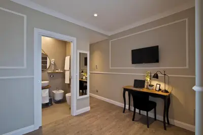 a room with a desk and a bathroom with a toilet at Seven Suites in Rome