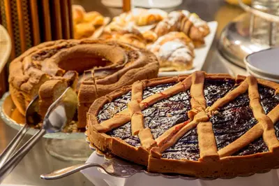 a pie sitting on top of a table with other pastries at La Residenza in Rome