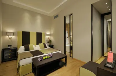 a bedroom with a king sized bed and a table at Alpi Hotel in Rome