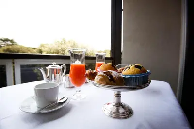 a table with a plate of muffins and a cup of orange juice at Albani Hotel Roma in Rome