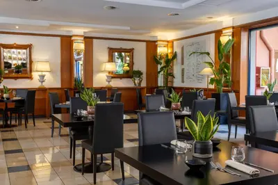 a restaurant with tables and chairs and plants at Grand Hotel Tiberio in Rome