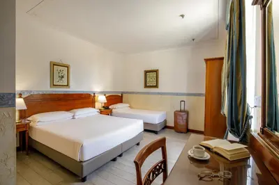 a hotel room with a bed and a desk and a table at Hotel Alessandrino in Rome