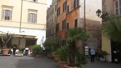a courtyard with potted plants in an old building at Vetrina Holidays Apartment Navona in Rome