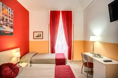 a bedroom with a bed and a desk and a window at Magnifico Rome in Rome