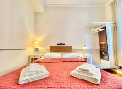 a bedroom with a red bed with two white towels on it at Roome B&B in Rome