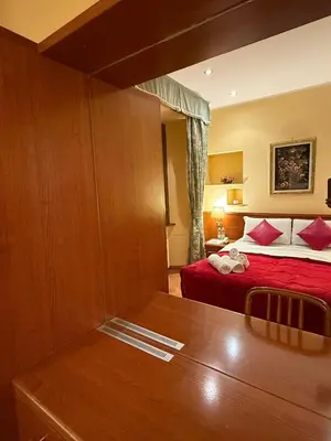 a hotel room with a bed with red sheets at Hotel Fenicia in Rome