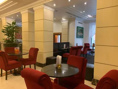 a waiting room with tables and red chairs at Hotel dei Mellini in Rome