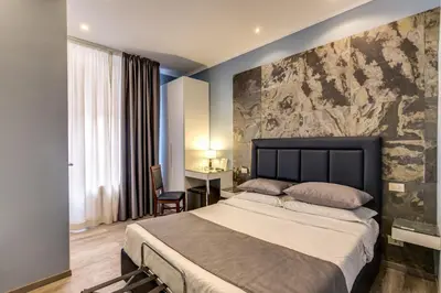 a bedroom with a large bed and a desk at Residenza Belli Inn in Rome