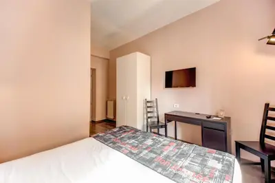 a bedroom with a bed and a desk and a table at Residenza Belli Inn in Rome