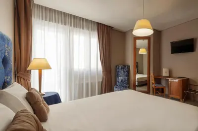 a hotel room with a large bed and a window at BeYou Hotel Ponte Milvio in Rome