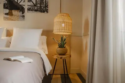 a bedroom with a bed with a lamp and a book at room Select Via Veneto in Rome
