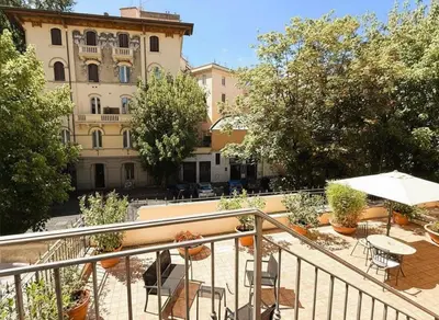 a balcony with tables and chairs and a building at Le Clarisse Trastevere in Rome