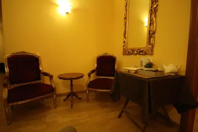 a room with two chairs and a table and a mirror at Hotel Cherubini in Rome