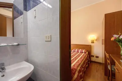 a bathroom with a sink and a bed in a room at Buonarroti Home in Rome
