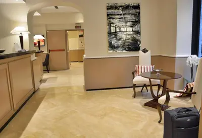 a hotel lobby with a table and chairs at LH Hotel Lloyd Roma in Rome