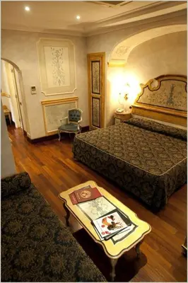 a hotel room with two beds and a table with a book at Hotel Villa San Pio in Rome