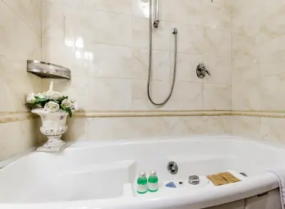 a white bath tub in a bathroom with a shower at Luxury Rooms H 2000 Roma in Rome