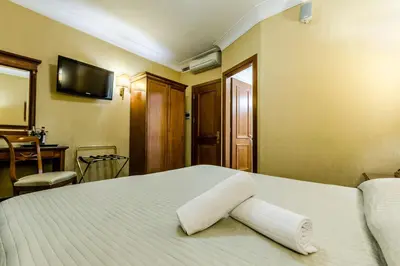 a bedroom with a bed with two towels on it at Luxury Rooms H 2000 Roma in Rome