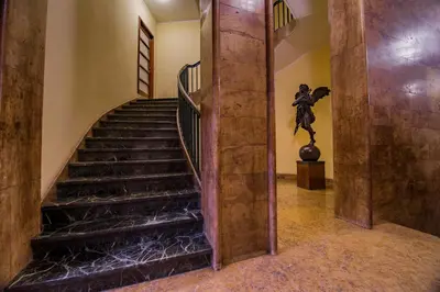 a spiral staircase in a building with a statue at Luxury Rooms H 2000 Roma in Rome