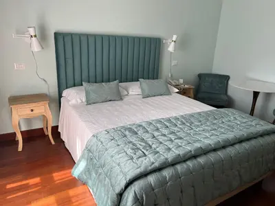 a bedroom with a large bed with a green headboard at Hotel Fenix in Rome
