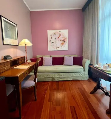a living room with a couch and a desk at Hotel Fenix in Rome