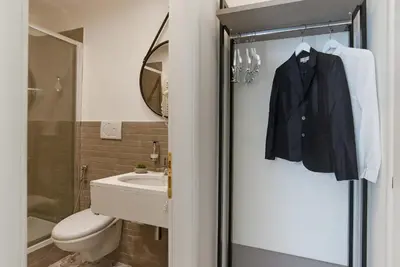 a bathroom with a black jacket hanging on a door at 94Rooms Vatican Guest House- Scipioni in Rome