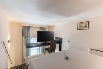 a hotel room with a bed and a desk with a television at Best Western Plus Hotel Universo in Rome