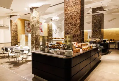 a restaurant with a counter with food on it at Best Western Premier Hotel Royal Santina in Rome