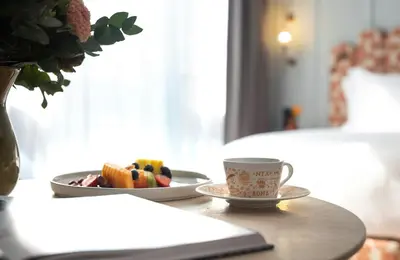 a table with a plate of fruit and a cup of coffee at NYX Hotel Rome by Leonardo Hotels in Rome