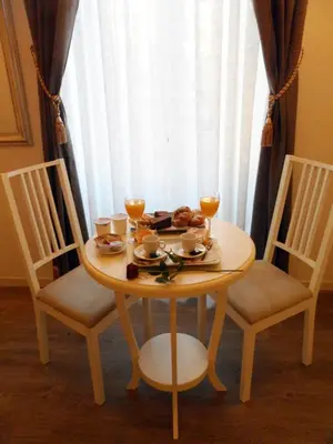 a wooden table with two chairs and glasses of wine at Dante's in Vaticano in Rome
