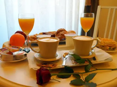 a table with two cups of coffee and two glasses of orange juice at Dante's in Vaticano in Rome