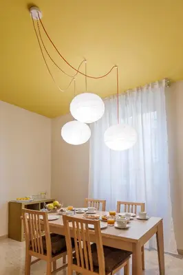 a dining room table with four chairs and lights at B&B L'Amaca in Rome