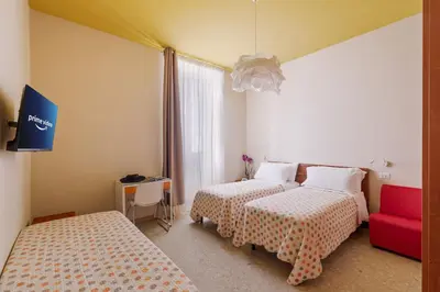 a room with two beds and a red couch at B&B L'Amaca in Rome