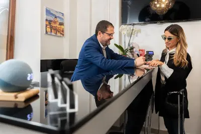 a man and a woman standing at a counter at Al Viminale Hill Inn & Hotel in Rome