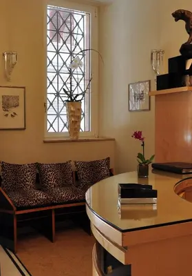 a living room with a table and a couch and a window at Hotel Gregoriana in Rome
